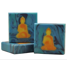 Load image into Gallery viewer, Frontansicht der Yellow Buddha Seife mit gelbem Buddha auf blauem Wirbel-Hintergrund und natürlichen Inhaltsstoffen
