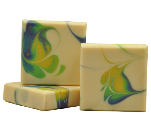 Three swirled soap bars with green, blue, and yellow colors on a white background