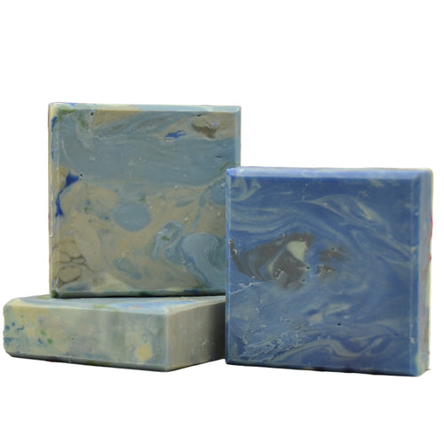 Three marbled blue and gray soap bars on a white fabric background