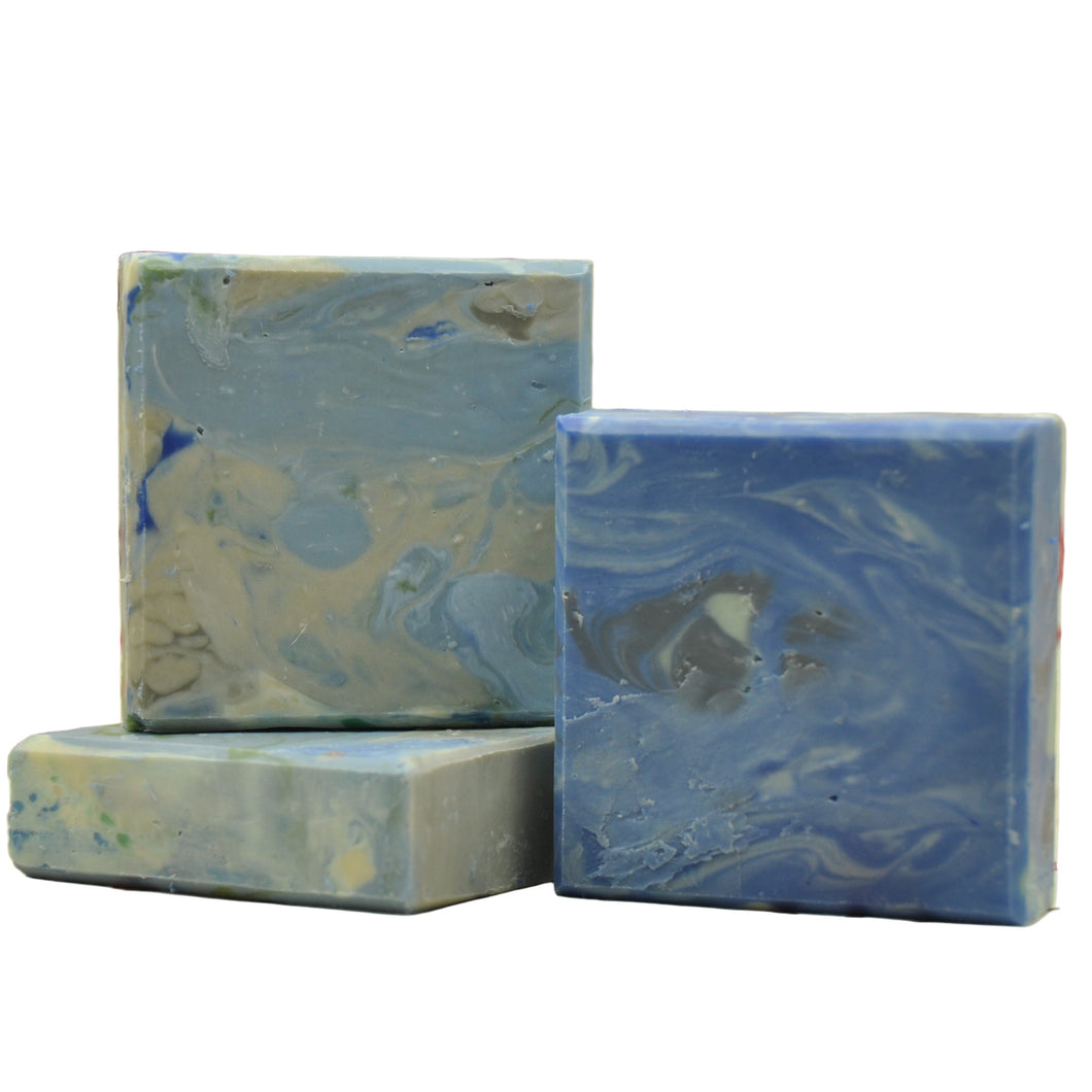 Three marbled blue and gray soap bars on a white fabric background