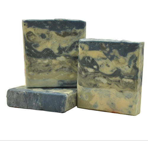 Three bars of marbled soap on a white fabric background
