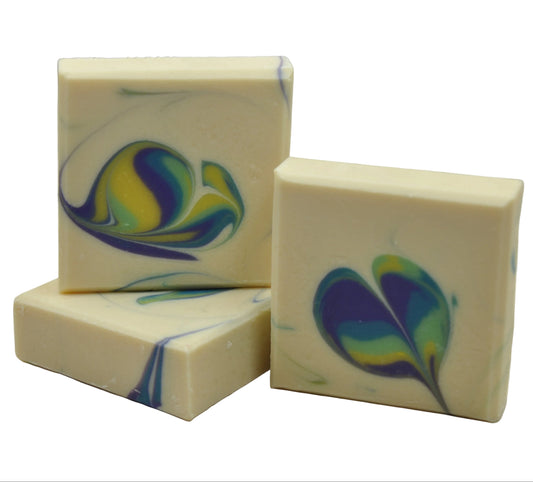 Handgemachte Seife in Cremeweiß mit buntem Pfauenfeder-Swirl in Blau, Grün und Gelb, drei Stück