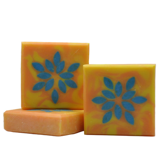 Drei Seifen mit einem Sternmotiv, das sich durch die Seife zieht; der Stern ist blau auf orange-gelbem Hintergrund
