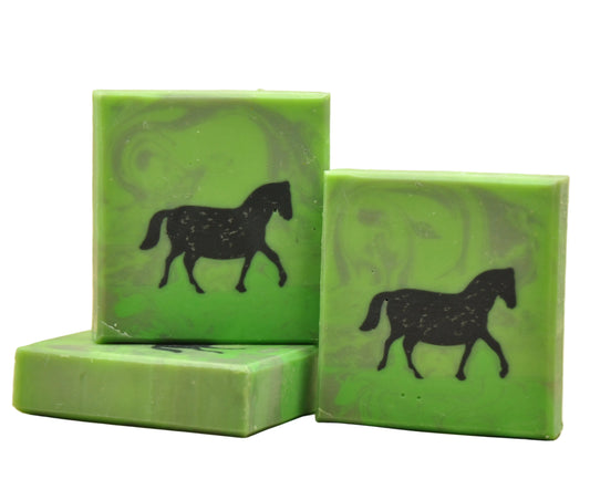 Drei Stücke handgemachte Ziegenmilchseife namens Pferd, hellgrün mit dunklen Wirbeln und einer schwarzen Pferde-Silhouette, die als Eingussdesign durch die gesamte Seife verläuft, duftend nach Zitrus und Kiefer.  geschenkidee