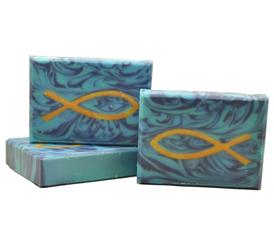 Handgemachte Naturseife mit Ichthys-Fischsymbol auf blauem Hintergrund in Gelb-Orange
