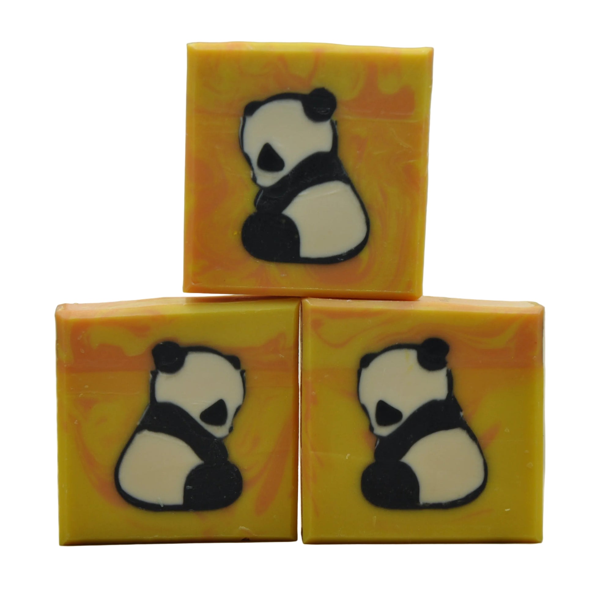 Handgemachte Kaltprozess-Ziegenmilchseife mit einem Panda-Motiv, das den gesamten Riegel durchzieht, auf warmem gelb-orangefarbenem Hintergrund – Panda Naturseife, einzigartiges Geschenk